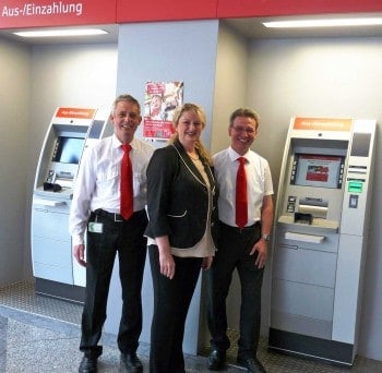 Eugen Bakes, Manuela Dinkel und Norbert Kleemann von der Sparkasse Fürth zwischen den beiden 5-Kassetter-Recyclern im SB-Bereich der HauptstelleWincor-Nixdorf