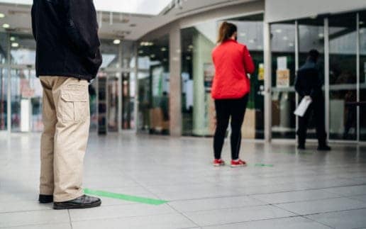 People standing in line front of bank/store due to coronavirus pandemic safety guideline.COVID-19 safe social distancing practice.Quarantine financial crisis,banking,loans.Spaced out queue.Crowd-limit