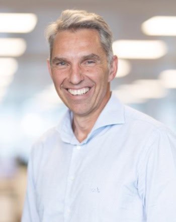 Das Bild zeigt Lars Lathan, Cloud and Software Architect bei GFT. Er lächelt in einem modernen Büro mit unscharfem Hintergrund. Im Kontext von FinOps ist die Optimierung von Ressourcen entscheidend, um Effizienz zu steigern und Kosten zu minimieren. Die Implementierung geeigneter Dashboards kann dabei unterstützen, die Finanz-IT-Teams bei der Überwachung und Analyse ihrer Cloud-Ausgaben zu unterstützen.