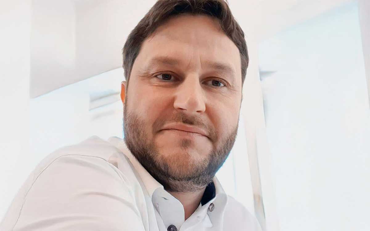 Tobias Ehret, Gründer und Geschäftsführer von finwyz, präsentiert sich in einem modernen Büro. Der Fokus liegt auf der Diskussion über Low Code-Plattformen und deren Rolle in der digitalen Transformation von Geschäftsmodellen im Finanzsektor.